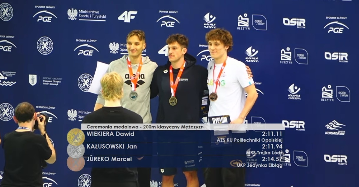 Elbląg, Marcel Jureko (z prawej) z brązowym medalem MP (kadr z transmisji na kanale YT Polskiego Związku Pływackiego) Elbląg, Marcel Jureko (z prawej) z brązowym medalem MP (kadr z transmisji na kanale YT Polskiego Związku Pływackiego)