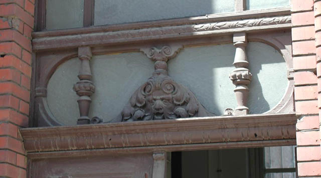 Drewniany maszkaron nad drzwiami budynku
przy ulicy 12-Lutego


